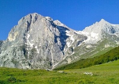 Il Gran Sasso d'Italia - Abruzzo Fare trekking ai piedi del Gran Sasso d’Italia è un'esperienza unica che permette di immergersi nella bellezza incontaminata di uno dei massicci montuosi più affascinanti dell’Appennino. L'area circostante offre una vasta gamma di itinerari, adatti a tutti i livelli di difficoltà, che si snodano tra vallate, prati fioriti e boschi di faggio, regalando panorami spettacolari sulle vette imponenti e sulle distese verdi sottostanti. Percorrendo i sentieri che partono dalla Piana di Campo Imperatore, uno degli altopiani più vasti d’Italia, si ha l’opportunità di godere di un paesaggio quasi surreale, dominato dalle cime del Corno Grande e del Corno Piccolo. Qui, tra pascoli e panorami mozzafiato, è possibile immergersi in una tranquillità unica, a pochi passi dai rifugi alpini dove trovare riparo e ristoro. I percorsi non sono solo un piacere per gli occhi, ma anche un'opportunità per avvicinarsi alla fauna locale: dai camosci che scalano ripide pareti rocciose alle aquile reali che sorvolano le valli, la biodiversità del Gran Sasso è un richiamo irresistibile per chi ama la natura selvaggia. I sentieri sono ben segnalati e consentono di percorrere sia tratti più brevi, ideali per una passeggiata pomeridiana, che itinerari più impegnativi che si avvicinano alle cime, regalando una sfida entusiasmante agli escursionisti più esperti. Tra gli angoli più suggestivi della zona, il borgo di Santo Stefano di Sessanio, con le sue case in pietra, rappresenta il punto di partenza ideale per escursioni che conducono a Rocca Calascio, una delle fortezze più affascinanti d’Italia, che spunta sopra il paesaggio come un’antica sentinella. Da questo punto, lo sguardo si perde a 360 gradi sulle valli e sulla maestosità del Gran Sasso, creando un ricordo indelebile di un’esperienza di trekking. Nonostante l'altezza, il trekking ai piedi del Gran Sasso è praticabile anche in primavera e autunno, quando il clima è più mite e la natura offre spettacolari colori autunnali o fioriture primaverili. Sia che si scelga di avventurarsi lungo sentieri noti o di esplorare i percorsi meno battuti, ogni passo sui monti del Gran Sasso è una possibilità di scoprire la tranquillità, la storia e la biodiversità di questa regione dell'Appennino, lontana dalla frenesia della vita quotidiana.