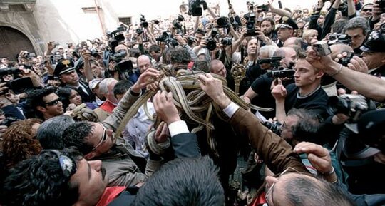 La festa dei Serpari di Cocullo è una delle più affascinanti manifestazioni di tradizione e folclore popolare in Abruzzo, capace di mescolare antiche credenze pagane e devozione religiosa. Celebrata ogni anno il 1° maggio, questa festa si tiene in onore di San Domenico Abate, il santo protettore contro i morsi dei serpenti e le malattie degli animali. Le radici di questa tradizione affondano in epoche lontane, quando le popolazioni italiche veneravano i serpenti come simboli di rigenerazione e fertilità. Con l’avvento del Cristianesimo, questi culti ancestrali furono reinterpretati nel contesto del culto cristiano, mantenendo però intatto il legame con la natura e il territorio. Il momento più caratteristico della festa è la processione della statua di San Domenico, interamente ricoperta da serpenti vivi raccolti dai serpari, figure centrali della celebrazione. Questi rettili, principalmente innocui colubri, vengono avvolti intorno alla statua e accompagnano il santo lungo le stradine del borgo, tra la folla di fedeli e visitatori. Questo rituale, che può apparire insolito e suggestivo, rappresenta un forte legame simbolico tra il sacro e il potere rigenerativo della natura, incarnato proprio dai serpenti. La processione è accompagnata da canti religiosi, preghiere e un clima di grande partecipazione collettiva. I serpari sono i veri protagonisti di questa tradizione, custodi di un sapere antico tramandato di generazione in generazione. La loro abilità nel catturare e maneggiare i serpenti è accompagnata da un profondo rispetto per questi animali, che vengono trattati con cura e liberati al termine della festa. Un tempo, i serpari erano anche esperti nel preparare rimedi naturali per i morsi dei serpenti, un’abilità preziosa per le comunità rurali dell’Appennino. Oggi, il loro ruolo si è trasformato, ma continua a rappresentare una connessione diretta con le radici profonde di questa celebrazione. Durante la festa, il borgo di Cocullo si trasforma in un vivace centro di incontro e festa popolare. Le strade si riempiono di mercati, musica tradizionale e sapori locali, offrendo ai visitatori un’esperienza autentica della cultura abruzzese. Le specialità gastronomiche del territorio, come formaggi, salumi e dolci, arricchiscono l’atmosfera di convivialità, mentre la partecipazione della comunità locale rafforza il senso di appartenenza e continuità. Questa fusione tra sacro e profano, tra devozione e celebrazione, rende la festa dei Serpari un evento unico nel suo genere. La festa dei Serpari non è solo una tradizione folcloristica, ma anche un simbolo dell’identità culturale abruzzese. Attraverso il suo rituale singolare e la partecipazione collettiva, essa racconta una storia di rispetto per la natura, resilienza delle comunità montane e continuità delle tradizioni. Ogni anno, migliaia di persone si riuniscono a Cocullo per assistere a questo spettacolo straordinario, immergendosi in un’atmosfera sospesa tra passato e presente, dove fede e folclore convivono in perfetta armonia.