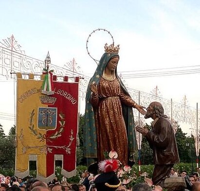 Il Pellegrinaggio della Madonna dei Miracoli a Casalbordino è una delle manifestazioni di fede più sentite della provincia di Chieti e dell’intero Abruzzo. Ogni anno, dall’9 all’11 giugno, migliaia di pellegrini si riversano nel santuario dedicato alla Vergine, situato nella località Miracoli di Casalbordino, per rinnovare la propria devozione e chiedere grazie. Questo evento affonda le sue radici in una tradizione secolare, nata a seguito dell’apparizione della Madonna a un contadino di Pollutri, Alessandro Muzio, l’11 giugno 1576. La Madonna, secondo il racconto tramandato, ammonì il devoto sull’importanza della santificazione delle feste, lasciando un segno indelebile nella spiritualità del luogo. Il santuario, inizialmente una semplice cappella rurale, si sviluppò nel corso dei secoli fino a divenire una basilica di riferimento per l’intero territorio. L’attuale struttura risale al XX secolo ed è stata consacrata nel 1962, dopo importanti ampliamenti per accogliere il numero sempre crescente di fedeli. La chiesa, con la sua imponente cupola e il chiostro adiacente, rappresenta un punto di incontro tra storia e fede. All’interno, spicca l’altare maggiore che custodisce l’effigie della Madonna dei Miracoli, raffigurata in un’iconografia tradizionale: avvolta in una luce celestiale, seduta su una quercia, mentre si rivolge con gesto benevolo al fedele inginocchiato. Durante il pellegrinaggio, le strade che conducono al santuario si riempiono di gruppi di fedeli che giungono anche a piedi dai paesi limitrofi, in un cammino di preghiera e raccoglimento. Un tempo, il pellegrinaggio era caratterizzato da riti di forte intensità emotiva, con penitenti che avanzavano scalzi o in ginocchio, manifestando la loro fede con atti di sacrificio. Oggi, pur avendo perso alcune delle sue espressioni più arcaiche, la celebrazione mantiene un’atmosfera di profonda spiritualità, con messe solenni, processioni e momenti di preghiera collettiva che rafforzano il senso di comunità e devozione. Il pellegrinaggio alla Madonna dei Miracoli ha influenzato profondamente la cultura locale e ha ispirato artisti e scrittori. Gabriele D’Annunzio ne descrisse le scene di devozione nel suo romanzo Il Trionfo della Morte, con toni talvolta critici, ma riconoscendo la potenza della fede popolare. Anche il pittore Francesco Paolo Michetti immortalò l’evento nel celebre dipinto Gli Storpi, raffigurando la processione di fedeli che si affidano alla Madonna per ottenere guarigioni e protezione. Queste rappresentazioni artistiche testimoniano l’importanza storica e sociale della celebrazione, che ancora oggi continua a richiamare pellegrini da tutta la regione. Nonostante il passare del tempo, il culto della Madonna dei Miracoli rimane vivo e radicato nella tradizione popolare. Ancora oggi, molti fedeli portano ex-voto come segno di gratitudine per le grazie ricevute, alimentando un legame profondo tra il santuario e la comunità. Il pellegrinaggio rappresenta non solo un momento di fede e preghiera, ma anche un’occasione per riscoprire le radici culturali del territorio, confermando Casalbordino come un centro spirituale di grande rilievo in Abruzzo.