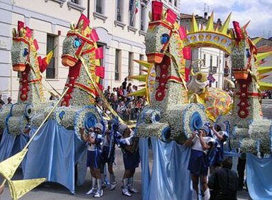La "Festa del Narciso" a Rocca di Mezzo, in provincia de L'Aquila, è una delle manifestazioni più affascinanti e sentite della tradizione abruzzese. Ogni anno, nel cuore della primavera, il piccolo paese si trasforma in un'esplosione di colori e profumi grazie alla celebrazione di uno dei fiori più iconici della regione: il narciso. Questo fiore, che cresce rigoglioso nei prati e nelle colline circostanti, diventa il simbolo della festa, unendo la bellezza naturale al folklore popolare di Rocca di Mezzo. La festa si svolge tra la fine di maggio e i primi giorni di giugno, periodo in cui i narcisi sono al culmine della loro fioritura, e la comunità si prepara ad accogliere la nuova stagione con gioia e allegria. Il cuore della festa è rappresentato dalla creazione e dalla sfilata dei carri allegorici, che vengono decorati con migliaia di narcisi freschi. Il lavoro di preparazione inizia settimane prima dell'evento, con i residenti che collaborano per costruire i carri e raccogliere i fiori. La settimana che precede la festa è particolarmente intensa: le ragazze del paese vanno nei campi a raccogliere i narcisi, mentre gli uomini lavorano senza sosta per completare le strutture dei carri. La sera del sabato, dopo il tramonto, comincia l’infioratura vera e propria, un rituale che si protrae fino a notte fonda, quando i carri vengono ricoperti di fiori in modo da renderli pronti per la sfilata del giorno successivo. Questa tradizione, che unisce arte, natura e lavoro di comunità, è arricchita da una forte componente di spettacolo. I carri allegorici, veri e propri capolavori di arte floreale, sfilano per le vie di Rocca di Mezzo accompagnati da gruppi folkloristici e musica tradizionale. La festa coinvolge tutta la comunità, dai più giovani ai più anziani, che partecipano con entusiasmo alle danze, ai canti e alle rappresentazioni che celebrano la bellezza del narciso e l’arrivo della primavera. La sfilata dei carri è un momento culminante, ma la festa si estende per tutta la giornata, con eventi che animano il paese fino a sera. La "Festa del Narciso" affonda le sue radici nella mitologia antica, richiamando la storia di Narciso, il giovane che si innamorò della propria immagine riflessa nell’acqua e che, per punizione, venne trasformato in un fiore. Questo mito, tramandato da Ovidio nelle "Metamorfosi", trova nella figura del narciso un simbolo di bellezza, solitudine e vanità. La festa, però, non si limita a raccontare la leggenda, ma celebra anche la rinascita della natura, con il narciso che, con la sua fragranza e i suoi colori vivaci, annuncia l’arrivo della bella stagione. Il fiore diventa quindi simbolo di speranza e di rinnovamento, un messaggio di gioia che attraversa i secoli e che la comunità di Rocca di Mezzo continua a onorare con grande passione. In Abruzzo, il narciso tazzetta (Narcissus tazetta) è la varietà più diffusa, particolarmente presente nella zona del Vastese, lungo la Valle del Trigno e sull’Altopiano delle Rocche. Questo fiore, dalla fragranza inebriante, è particolarmente apprezzato per la sua capacità di fiorire abbondantemente in primavera, colorando i prati di bianco e giallo. Il narciso tazzetta è dunque il protagonista indiscusso della festa, il cui profumo e la cui bellezza arricchiscono le tradizioni locali e contribuiscono a rafforzare il legame tra la comunità e la natura circostante. La festa, oltre a essere una celebrazione della bellezza del fiore, è anche un momento di condivisione e di coesione sociale, un’occasione in cui la comunità si ritrova per festeggiare insieme il ciclo della vita che rinasce con la primavera.