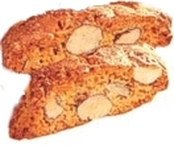 I Papatelli, tipici dolci natalizi della provincia di Teramo, sono un perfetto equilibrio di dolcezza e piccantezza. La base del dolce è rappresentata dal miele, che, sciolto a fuoco lento, diventa l’elemento unificante degli altri ingredienti. La combinazione di mandorle intere, che vengono lasciate con la buccia per aggiungere un tocco di rusticità, e la buccia grattugiata delle arance conferisce una freschezza al sapore, mentre il pepe bianco, tradizionale e inconfondibile, dona al dolce una nota piccante che lo rende unico. L’ingrediente più caratteristico dei Papatelli è sicuramente il pepe, che, pur essendo un condimento insolito per i dolci, riesce a integrarsi perfettamente con la dolcezza del miele e la croccantezza delle mandorle. Questa combinazione inaspettata è ciò che distingue i Papatelli dagli altri dolci tipici natalizi, regalando a ogni morso un’esplosione di sapori contrastanti ma armoniosi. Il pepe non è mai eccessivo, ma riesce a bilanciare e a esaltare gli altri ingredienti con discrezione. La preparazione dei Papatelli è un processo che richiede pazienza, soprattutto quando si tratta di mescolare il miele caldo con la farina. L’impasto, lavorato a mano mentre è ancora caldo, diventa denso e gommoso, un segno che gli ingredienti si sono ben amalgamati. La fase finale della lavorazione, che consiste nel modellare i dolci in piccoli panetti e schiacciarli, dà loro una forma semplice ma invitante. Nonostante la preparazione piuttosto impegnativa, il risultato finale ripaga ampiamente lo sforzo. La cottura lenta e a bassa temperatura permette ai Papatelli di sviluppare una consistenza compatta, ma al tempo stesso leggera, con un delicato colorito dorato. Dopo la cottura, vengono tagliati in fette sottili, che permettono di apprezzare appieno la combinazione di sapori. I Papatelli, sebbene siano tradizionalmente consumati nel periodo natalizio, sono un dolce che conserva il sapore della tradizione abruzzese, rendendo ogni assaggio una vera e propria riscoperta delle radici culinarie della provincia di Teramo.