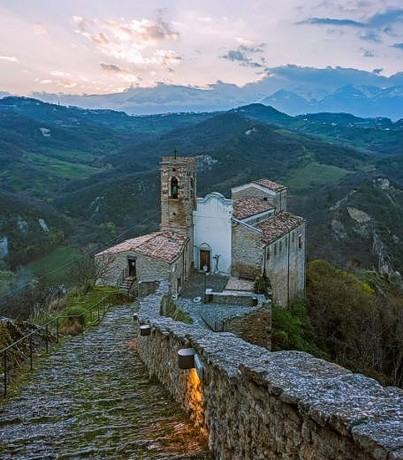 La Chiesa di San Pietro a Roccascalegna (Ch) Il culto di San Nicola di Bari, patrono della Chiesa di San Nicola a Roccascalegna, è uno degli aspetti più importanti della vita religiosa della comunità locale. San Nicola, noto per la sua generosità e per i numerosi miracoli che gli sono attribuiti, è venerato da secoli come protettore dei viaggiatori, dei mercanti e dei bambini. La Chiesa di San Nicola, con la sua intima devozione, è un punto di riferimento spirituale per i fedeli del paese, che si riuniscono per celebrare la sua festa il 6 dicembre. In questa giornata, la chiesa diventa il centro di un'intensa vita religiosa, con una messa solenne e una processione che coinvolge tutta la comunità. La devozione a San Nicola ha radici profonde nella storia di Roccascalegna, dove il santo è stato sempre considerato una figura di speranza e di protezione. La chiesa ospita numerose manifestazioni di fede, che vanno oltre la festa liturgica del santo, e si estendono lungo tutto l'anno con preghiere e invocazioni. Molti fedeli si recano in pellegrinaggio alla chiesa per chiedere l'intercessione di San Nicola in momenti di difficoltà o per esprimere gratitudine per le grazie ricevute. La chiesa di San Nicola, infatti, è vista come un luogo dove il santo intercede per coloro che lo invocano con fervore. Il culto di San Nicola non si limita solo alla celebrazione liturgica, ma coinvolge anche le tradizioni locali, che sono state trasmesse di generazione in generazione. Le usanze legate alla festa del santo, come le processioni e le celebrazioni popolari, sono momenti di grande significato per la comunità. Queste tradizioni, che spesso uniscono spiritualità e folklore, rafforzano il legame tra i fedeli e il santo, e contribuiscono a mantenere viva la cultura religiosa di Roccascalegna. Il culto di San Nicola, infatti, non è solo un aspetto della vita religiosa, ma è anche parte integrante della vita sociale del paese. Oggi, il culto di San Nicola di Bari continua a essere un elemento fondamentale nella vita religiosa di Roccascalegna. La Chiesa di San Nicola rimane un luogo di grande devozione e spiritualità, dove i fedeli si raccolgono per pregare e celebrare il santo patrono. La sua figura è profondamente radicata nella tradizione del paese, e la chiesa resta un simbolo di protezione e di speranza per tutta la comunità. Il culto di San Nicola non solo mantiene viva la fede, ma rappresenta anche un elemento di identità culturale e spirituale per Roccascalegna e per tutti coloro che si avvicinano a questo luogo di culto. La Chiesa di San Pietro, situata nel comune di Roccascalegna, in provincia di Chieti, è un piccolo ma affascinante luogo di culto immerso nella natura. Il suo fascino è accentuato dalla posizione panoramica, che domina la valle sottostante e offre una vista spettacolare sui monti della zona. La chiesa, dedicata a San Nicola, uno dei santi più venerati in Abruzzo, ha radici che risalgono al Medioevo. La sua costruzione è legata a un'antica tradizione di devozione popolare che ha attraversato i secoli, con il culto di San Nicola che ha attratto molti fedeli della regione, soprattutto grazie alla sua figura di protettore dei viaggiatori e dei mercanti. Nel corso dei secoli, la Chiesa di San Nicola ha visto diversi interventi e restauri, che hanno contribuito a preservarne la struttura originaria. La semplicità architettonica della chiesa, con il suo caratteristico aspetto rustico, si inserisce perfettamente nel contesto montano circostante, conferendo al luogo un'atmosfera di serenità e spiritualità. Nonostante le sue dimensioni contenute, la chiesa conserva numerosi elementi decorativi che testimoniano la sua importanza storica, come gli affreschi e le sculture che adornano le pareti interne. Il culto di San Nicola di Bari ha sempre avuto un ruolo di primo piano per la comunità di Roccascalegna. La festa del santo, celebrata ogni anno il 6 dicembre, è un evento di grande rilievo religioso e sociale. Durante questa giornata, i fedeli si riuniscono per partecipare alla messa in onore di San Nicola e per pregare per la sua intercessione. La devozione popolare nei confronti del santo si manifesta anche in numerose tradizioni e usanze locali, che rendono la festa un'occasione di celebrazione e di raccoglimento per tutta la comunità. Oggi, La Chiesa di San Pietro continua a essere un punto di riferimento spirituale per Roccascalegna e per i pellegrini che giungono in visita. La sua bellezza discreta e la sua storia antica la rendono una meta ideale per chi cerca un luogo di pace e riflessione. La chiesa, pur essendo di dimensioni modeste, rappresenta un tesoro di fede e cultura che continua a essere custodito con amore dalla comunità locale, mantenendo viva la tradizione del culto di San Nicola in una delle zone più affascinanti dell'Abruzzo.