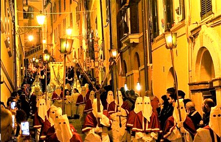 La Processione del Venerdì Santo a Chieti è uno degli eventi religiosi più suggestivi e antichi d'Italia, capace di evocare un'intensa spiritualità e un profondo senso di appartenenza alla tradizione. Le sue origini risalgono almeno al IX secolo, anche se la forma attuale è attestata dal XVI secolo, grazie all'Arciconfraternita del Sacro Monte dei Morti, che ancora oggi ne cura l'organizzazione. Ogni anno, al calar della sera del Venerdì Santo, la città si immerge in un’atmosfera solenne, fatta di luci soffuse, silenzi meditativi e il suono struggente del Miserere, una composizione di grande impatto emotivo che accompagna il corteo lungo le strade del centro storico. La processione è guidata dal Troccolante, una figura simbolica che, scuotendo la "troccola", un particolare strumento in legno e metallo, segna l'inizio del cammino penitenziale. Seguono i membri dell'Arciconfraternita, vestiti con il tradizionale saio nero e il cappuccio, e poi i vari gruppi che rappresentano scene della Passione di Cristo, portando antichi simboli come la croce, la corona di spine e il sudario. L’elemento più toccante è costituito dalla statua del Cristo Morto, trasportata su un baldacchino ornato di fiori e circondata da una moltitudine di confratelli e fedeli in preghiera. Il Miserere di Selecchy, eseguito da un’orchestra e da un coro di circa centocinquanta elementi, rappresenta il cuore musicale della processione e contribuisce a creare un’atmosfera unica e commovente. Questa composizione sacra, ispirata al Salmo 50, si tramanda da generazioni ed è diventata un vero simbolo della Settimana Santa teatina. Le sue note profonde e malinconiche si diffondono lungo il percorso, amplificate dal silenzio rispettoso dei presenti, e penetrano nell’animo di chi ascolta, rendendo l'evento un momento di intensa riflessione e partecipazione emotiva. Lungo il tragitto, la città sembra sospendere ogni attività: le luci dei lampioni vengono abbassate, le finestre si riempiono di candele e il rumore della quotidianità lascia spazio alla meditazione. I fedeli, molti dei quali arrivano anche da fuori regione, partecipano con devozione, seguendo il lento incedere della processione o assistendovi lungo i bordi delle strade. Questo rito collettivo, oltre a essere un’espressione di fede, rappresenta anche un forte legame con la storia e l’identità del territorio, rinsaldando ogni anno il senso di comunità tra i teatini. La Processione del Venerdì Santo di Chieti non è soltanto un evento religioso, ma un patrimonio culturale che attraversa i secoli e continua a emozionare chi vi prende parte. Il rispetto delle tradizioni, la sacralità del momento e la partecipazione corale della popolazione ne fanno un appuntamento imprescindibile per la città e per chiunque voglia vivere un’esperienza di intensa spiritualità. La sua unicità risiede proprio nell’armonia tra fede, musica e tradizione, elementi che si fondono in un rito che, pur appartenendo alla storia, riesce sempre a rinnovarsi nel cuore dei fedeli.