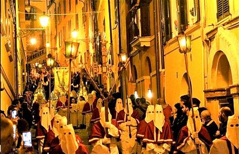 La Processione del Venerdì Santo a Chieti è uno degli eventi religiosi più suggestivi e antichi d'Italia, capace di evocare un'intensa spiritualità e un profondo senso di appartenenza alla tradizione. Le sue origini risalgono almeno al IX secolo, anche se la forma attuale è attestata dal XVI secolo, grazie all'Arciconfraternita del Sacro Monte dei Morti, che ancora oggi ne cura l'organizzazione. Ogni anno, al calar della sera del Venerdì Santo, la città si immerge in un’atmosfera solenne, fatta di luci soffuse, silenzi meditativi e il suono struggente del Miserere, una composizione di grande impatto emotivo che accompagna il corteo lungo le strade del centro storico. La processione è guidata dal Troccolante, una figura simbolica che, scuotendo la "troccola", un particolare strumento in legno e metallo, segna l'inizio del cammino penitenziale. Seguono i membri dell'Arciconfraternita, vestiti con il tradizionale saio nero e il cappuccio, e poi i vari gruppi che rappresentano scene della Passione di Cristo, portando antichi simboli come la croce, la corona di spine e il sudario. L’elemento più toccante è costituito dalla statua del Cristo Morto, trasportata su un baldacchino ornato di fiori e circondata da una moltitudine di confratelli e fedeli in preghiera. Il Miserere di Selecchy, eseguito da un’orchestra e da un coro di circa centocinquanta elementi, rappresenta il cuore musicale della processione e contribuisce a creare un’atmosfera unica e commovente. Questa composizione sacra, ispirata al Salmo 50, si tramanda da generazioni ed è diventata un vero simbolo della Settimana Santa teatina. Le sue note profonde e malinconiche si diffondono lungo il percorso, amplificate dal silenzio rispettoso dei presenti, e penetrano nell’animo di chi ascolta, rendendo l'evento un momento di intensa riflessione e partecipazione emotiva. Lungo il tragitto, la città sembra sospendere ogni attività: le luci dei lampioni vengono abbassate, le finestre si riempiono di candele e il rumore della quotidianità lascia spazio alla meditazione. I fedeli, molti dei quali arrivano anche da fuori regione, partecipano con devozione, seguendo il lento incedere della processione o assistendovi lungo i bordi delle strade. Questo rito collettivo, oltre a essere un’espressione di fede, rappresenta anche un forte legame con la storia e l’identità del territorio, rinsaldando ogni anno il senso di comunità tra i teatini. La Processione del Venerdì Santo di Chieti non è soltanto un evento religioso, ma un patrimonio culturale che attraversa i secoli e continua a emozionare chi vi prende parte. Il rispetto delle tradizioni, la sacralità del momento e la partecipazione corale della popolazione ne fanno un appuntamento imprescindibile per la città e per chiunque voglia vivere un’esperienza di intensa spiritualità. La sua unicità risiede proprio nell’armonia tra fede, musica e tradizione, elementi che si fondono in un rito che, pur appartenendo alla storia, riesce sempre a rinnovarsi nel cuore dei fedeli.
