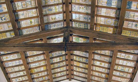 Una tradizione secolare. La ceramica e la maiolica rappresentano una delle espressioni più antiche e raffinate dell’artigianato tradizionale abruzzese. Questa arte affonda le sue radici nel Medioevo, quando venivano realizzati oggetti d’uso quotidiano come piatti, brocche e mattonelle, decorati con motivi simbolici e religiosi. Con il tempo, la produzione si è arricchita di elementi ornamentali, trasformando ogni pezzo in un’opera d’arte, frutto di abilità tecnica e sensibilità estetica tramandata di generazione in generazione. Castelli, culla della maiolica artistica: Il borgo di Castelli, ai piedi del Gran Sasso, è considerato uno dei centri ceramici più importanti d’Italia. Fin dal Rinascimento, le sue botteghe hanno prodotto maioliche di straordinaria qualità, apprezzate anche dalle corti nobiliari. Le decorazioni tipiche, dai colori vivaci e dai soggetti floreali o sacri, sono realizzate ancora oggi secondo tecniche antiche, come la smaltatura e la pittura a mano. A testimonianza di questa tradizione, Castelli ospita anche il Museo della Ceramica, che conserva opere storiche di grande valore. Rapino e la ceramica della Majella: Anche Rapino, in provincia di Chieti, vanta una lunga tradizione nella lavorazione della ceramica. Le sue creazioni si distinguono per l’eleganza delle forme e la vivacità dei colori, con motivi spesso ispirati alla natura e al paesaggio montano della Majella. Le botteghe artigiane del paese mantengono vive le tecniche tradizionali, adattandole talvolta al gusto contemporaneo, e contribuiscono alla valorizzazione dell’identità culturale locale attraverso eventi e mostre dedicate. Arte, simboli e identità culturale: La ceramica abruzzese non è solo un’attività artigianale, ma anche un’espressione dell’identità storica e culturale del territorio. Ogni oggetto racconta una storia: i simboli floreali richiamano il ciclo della vita, le figure sacre esprimono devozione, i colori intensi comunicano vitalità e orgoglio. Ancora oggi, la ceramica e la maiolica sono presenti in molti contesti domestici e pubblici, rappresentando un legame profondo tra passato e presente, tra arte e vita quotidiana.
