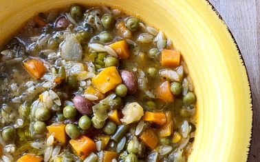 La Zuppa di verdure e legumi rappresenta un piatto tradizionale che esprime appieno la semplicità e la bontà della cucina abruzzese, in particolare della provincia di Pescara. I legumi, come fagioli e ceci, sono alla base di questa zuppa, e la loro cottura lunga e lenta permette di sprigionare sapori ricchi e profondi, che rendono ogni cucchiaiata particolarmente confortante. Il loro gusto delicato ma pieno, unito alla consistenza morbida che acquisiscono durante la cottura, conferisce alla zuppa un carattere rustico e avvolgente, perfetto per i piatti più sostanziosi della cucina regionale. Le verdure che accompagnano i legumi, come patate, carote e zucchine, completano la ricetta con un'armonia di dolcezza e freschezza. Le patate, che cuociono lentamente assorbendo i sapori del brodo, rendono la zuppa più corposa, mentre le carote e le zucchine aggiungono un tocco vivace e aromatico. Il sedano, con il suo profumo inconfondibile, dona una freschezza che bilancia la consistenza densa dei legumi, creando una sinfonia di sapori che si mescolano e si potenziano a vicenda. Questo connubio di verdure è una delle caratteristiche che rende la zuppa così equilibrata e nutriente. L'olio extravergine d'oliva, un ingrediente fondamentale della cucina abruzzese, arricchisce ulteriormente la zuppa con il suo sapore fruttato e leggermente piccante. Viene utilizzato per il soffritto, dove cipolla e aglio si dorano dolcemente, creando una base aromatica che farà da sfondo ai legumi e alle verdure. Il sapore deciso dell'olio abruzzese esalta la naturale dolcezza delle verdure e il gusto terroso dei legumi, rendendo il piatto ancora più ricco e saporito. L'olio non è solo un condimento, ma un elemento che unisce e armonizza gli ingredienti, esaltandone la freschezza. Infine, la Zuppa di verdure e legumi è arricchita da un tocco di rosmarino, che dona una nota aromatica inconfondibile, capace di legare tutti i sapori con eleganza. Questo piatto, che celebra la tradizione agricola e culinaria dell'Abruzzo, è perfetto per riscaldare le fredde giornate invernali, quando il suo calore e la sua ricchezza offrono comfort e nutrimento. La semplicità di questo piatto nasconde una complessità di sapori che racconta la storia di una terra ricca di ingredienti freschi e genuini, facendo della Zuppa di verdure e legumi una vera prelibatezza della cucina abruzzese.